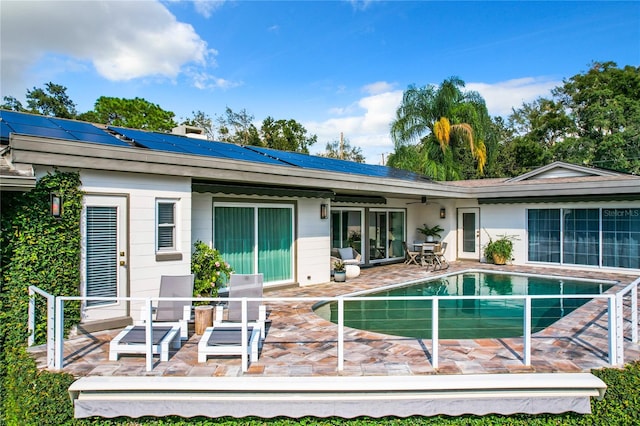 back of property featuring solar panels and a patio