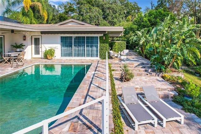 view of pool with ceiling fan and a patio