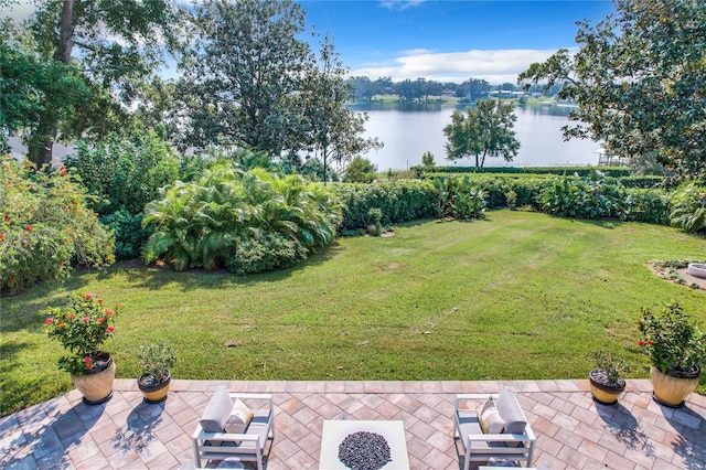 view of yard with a water view and a patio