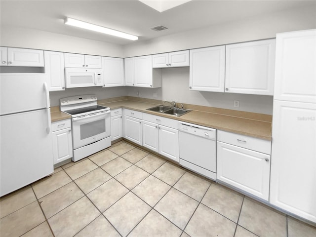 kitchen with light tile patterned floors, white cabinets, sink, and white appliances