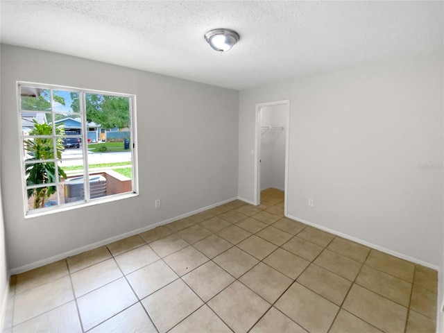 spare room with light tile patterned floors and a textured ceiling