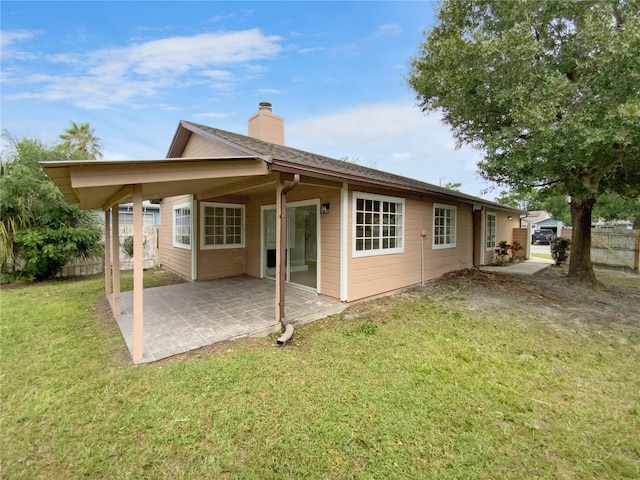 rear view of property with a yard and a patio area