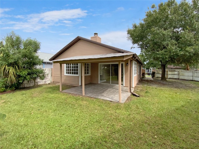 back of property featuring a patio and a yard