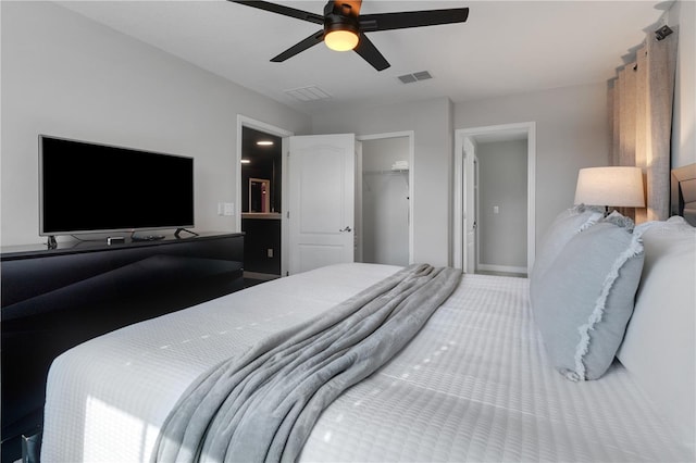 carpeted bedroom featuring a closet, a walk in closet, and ceiling fan