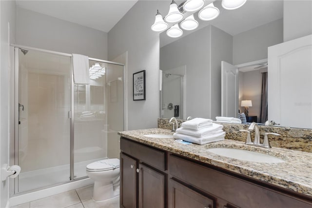 bathroom featuring toilet, tile patterned flooring, vanity, and a shower with door