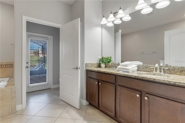 bathroom with vanity, a relaxing tiled tub, and tile patterned floors