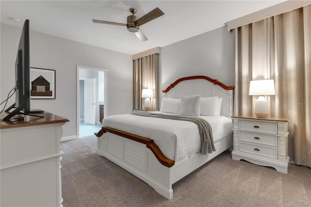 carpeted bedroom with ensuite bathroom and ceiling fan