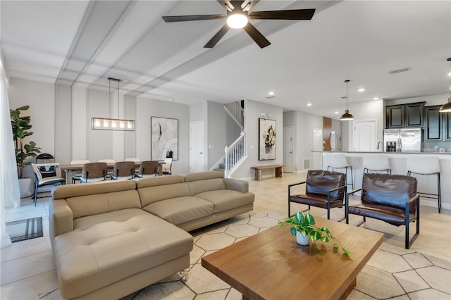 living room featuring ceiling fan with notable chandelier and light tile patterned floors