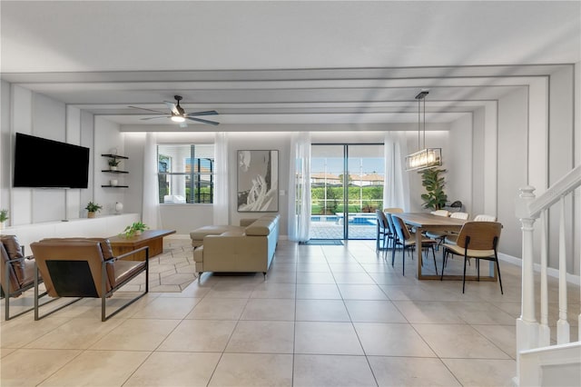 tiled living room with ceiling fan with notable chandelier and plenty of natural light