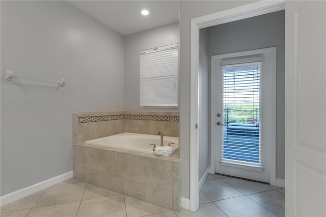 bathroom with tiled bath and tile patterned flooring