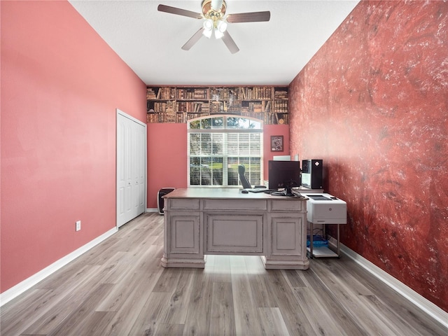 home office with light hardwood / wood-style flooring and ceiling fan