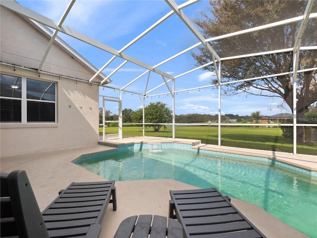 view of swimming pool with a yard, a patio, and a lanai