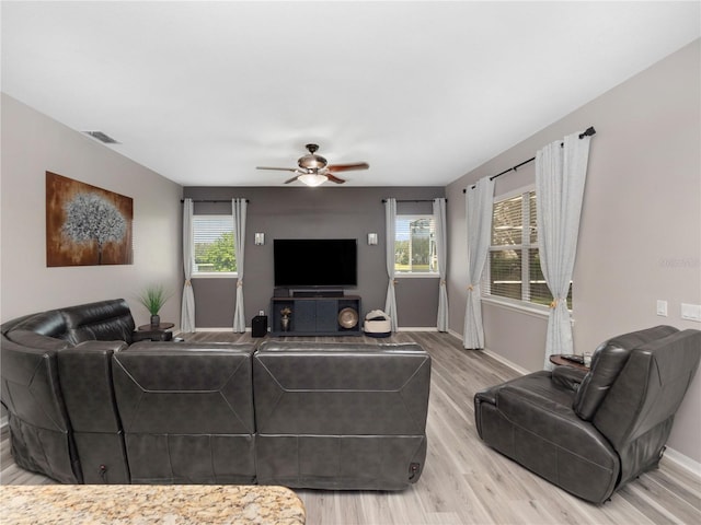 living room with light hardwood / wood-style flooring and ceiling fan