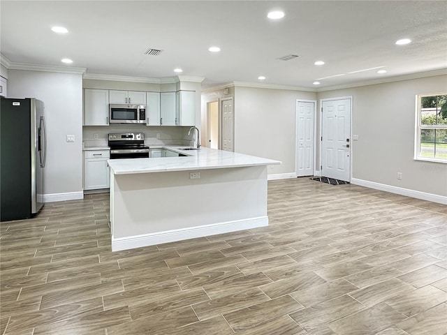 kitchen with light stone countertops, white cabinets, appliances with stainless steel finishes, and light wood-type flooring