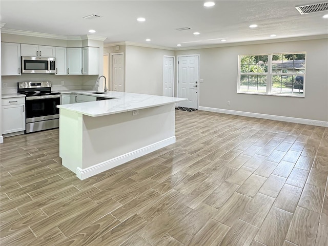 kitchen featuring light stone countertops, white cabinets, sink, light hardwood / wood-style flooring, and appliances with stainless steel finishes