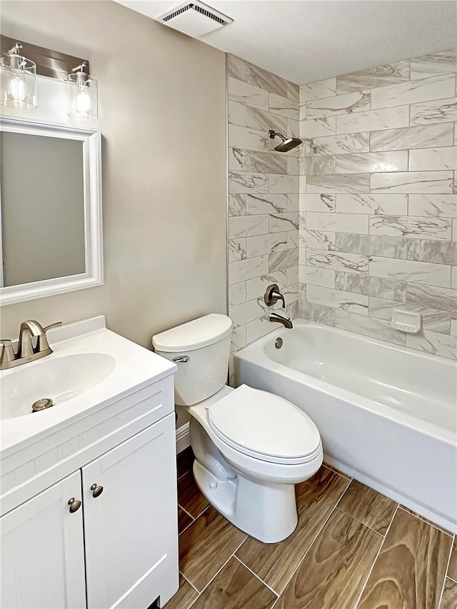 full bathroom with vanity, toilet, and tiled shower / bath