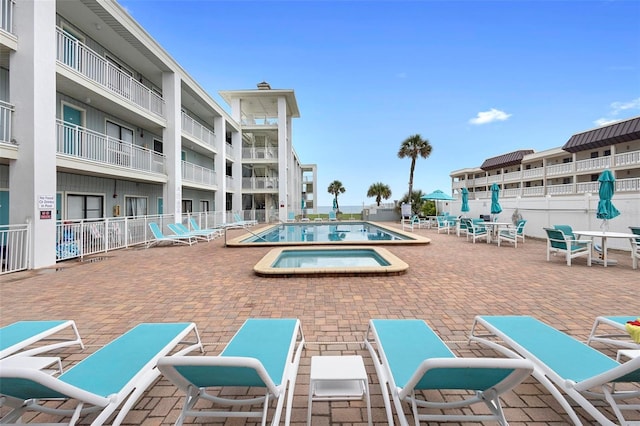 view of pool with a patio area and a hot tub