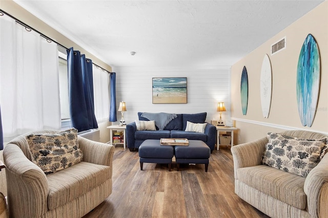 living area with visible vents and wood finished floors