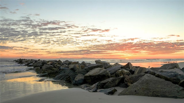 aerial view at dusk featuring a water view