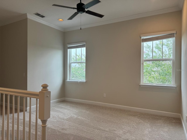 carpeted spare room with a healthy amount of sunlight and ornamental molding