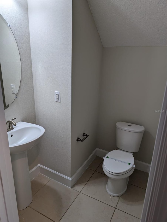 bathroom with tile patterned floors, a textured ceiling, and toilet