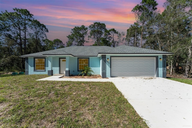 ranch-style house with a garage and a lawn