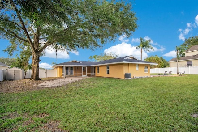 rear view of property featuring a patio area, central AC, a shed, and a lawn