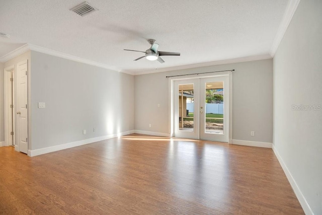 spare room with ceiling fan, a textured ceiling, light hardwood / wood-style flooring, ornamental molding, and french doors