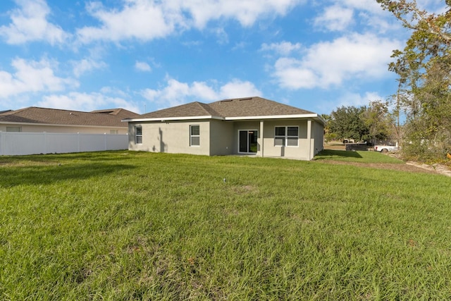 rear view of house featuring a lawn