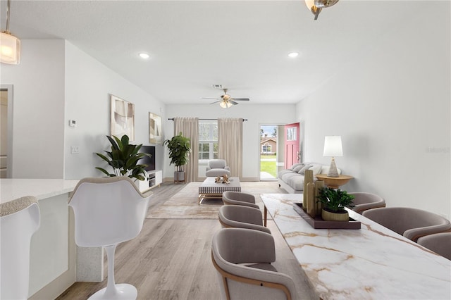 living room with ceiling fan and light hardwood / wood-style flooring