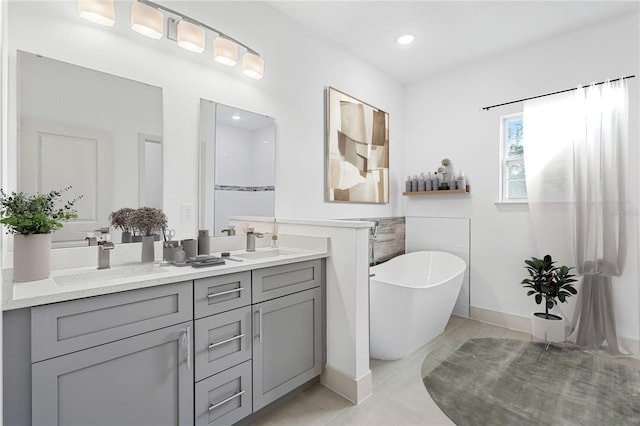 bathroom with tile patterned floors, vanity, and a tub to relax in