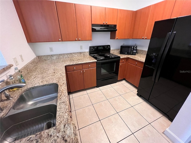 kitchen with light stone countertops, black appliances, sink, and light tile patterned floors