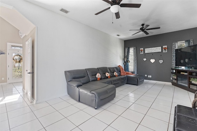 tiled living room with ceiling fan and a wealth of natural light