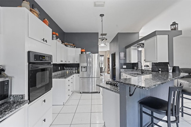 kitchen featuring sink, appliances with stainless steel finishes, white cabinetry, and dark stone countertops