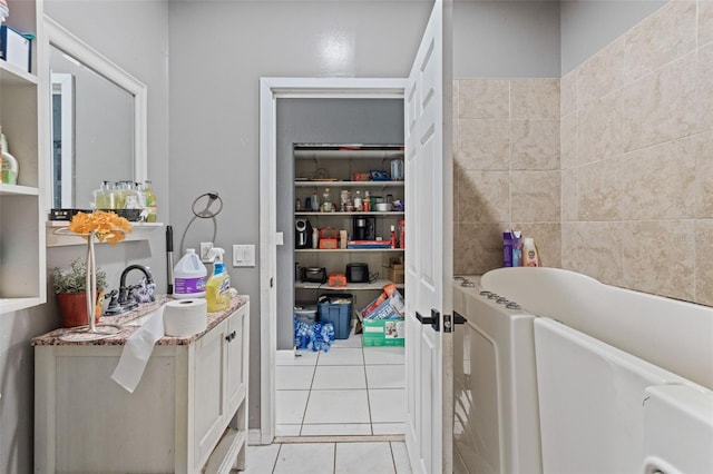 bathroom with vanity, tile patterned flooring, and a bathing tub