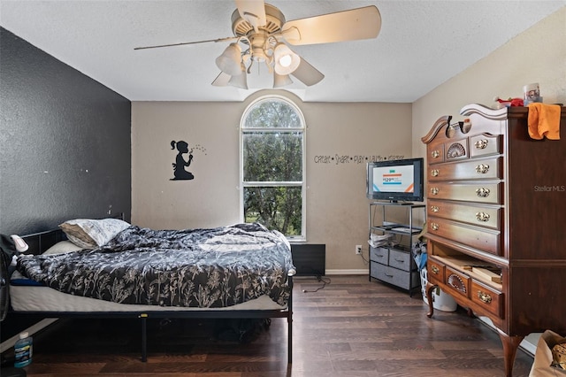 bedroom with dark hardwood / wood-style floors, a textured ceiling, and ceiling fan