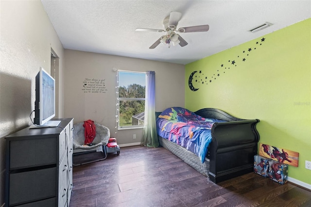 bedroom featuring a textured ceiling, dark wood-type flooring, and ceiling fan