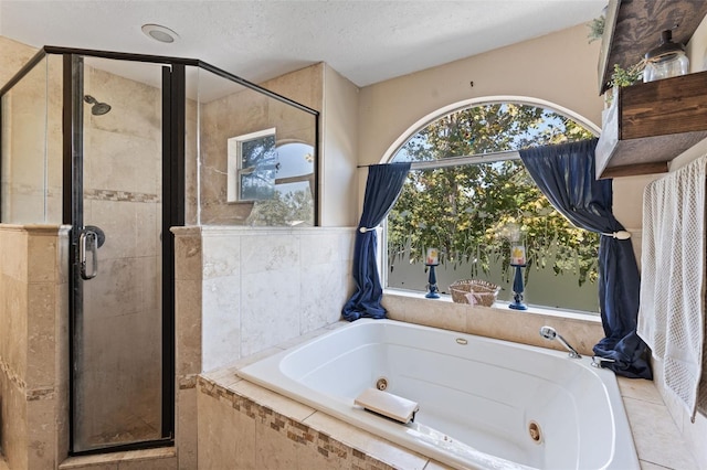 bathroom with a textured ceiling, plus walk in shower, and tile patterned flooring