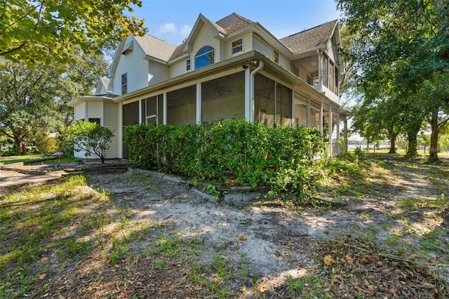 view of property exterior with a sunroom