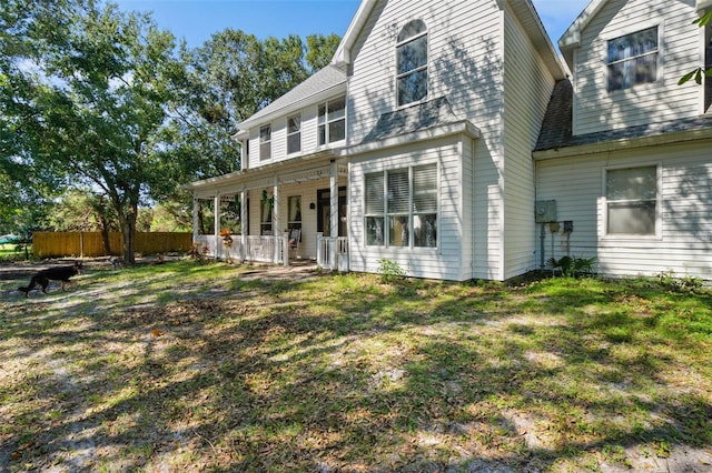 rear view of house featuring a yard