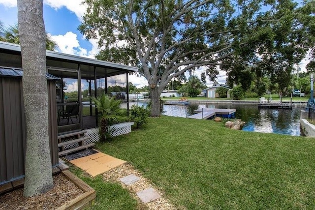 view of yard with a sunroom and a water view