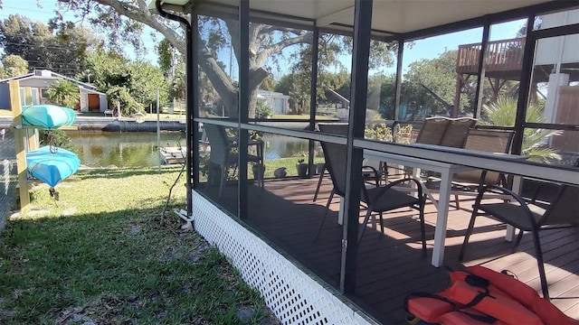 exterior space featuring a yard, a water view, and a sunroom