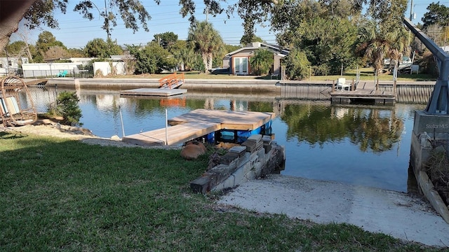 dock area with a lawn and a water view