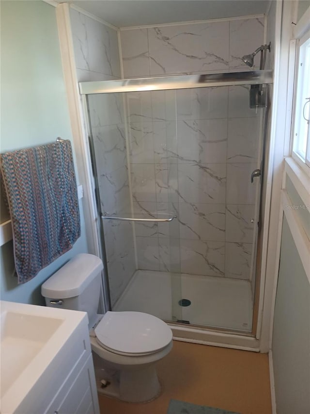 bathroom with vanity, a shower with shower door, and toilet