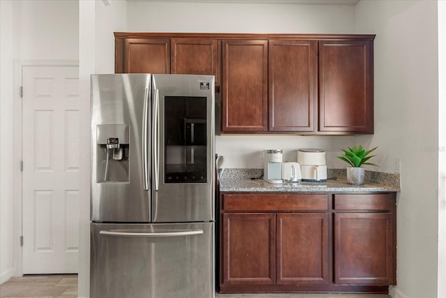 kitchen featuring stainless steel fridge and light stone counters