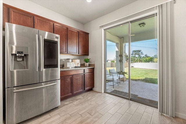 kitchen with stainless steel fridge and light hardwood / wood-style floors