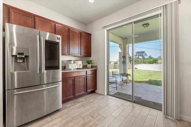 1909 Cayman Cove Cir, Saint Cloud, FL 34772 - kitchen featuring wood tiled floor, stainless steel refrigerator with ice dispenser, and baseboards