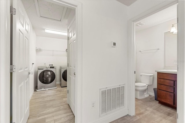 washroom with light hardwood / wood-style floors and independent washer and dryer