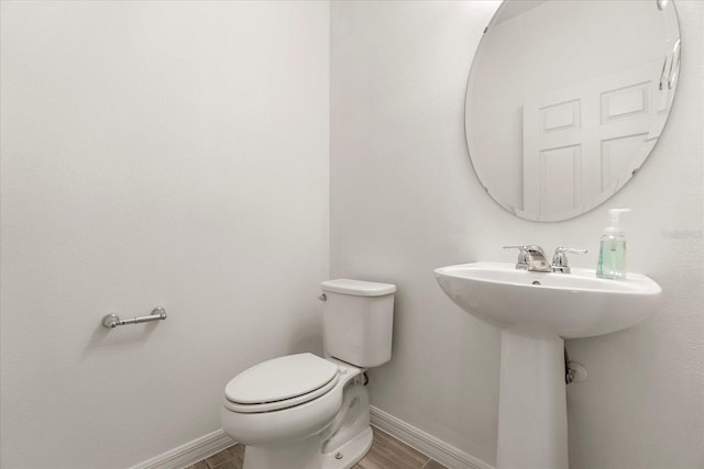 bathroom with toilet and hardwood / wood-style floors