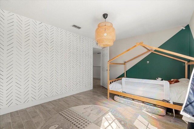 1909 Cayman Cove Cir, Saint Cloud, FL 34772 - bedroom featuring baseboards, an accent wall, wood finished floors, and visible vents